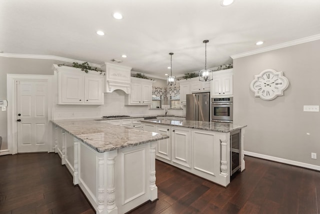 kitchen with light stone counters, a kitchen island, white cabinets, and appliances with stainless steel finishes