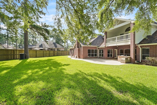 view of yard with central AC unit, a patio, and a balcony