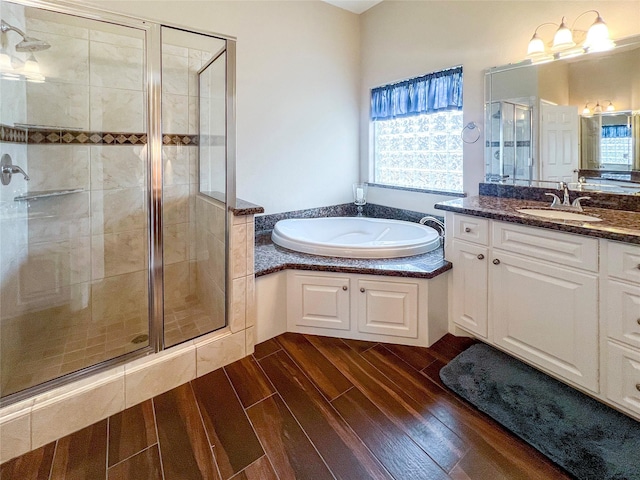 bathroom with hardwood / wood-style flooring, vanity, independent shower and bath, and a healthy amount of sunlight