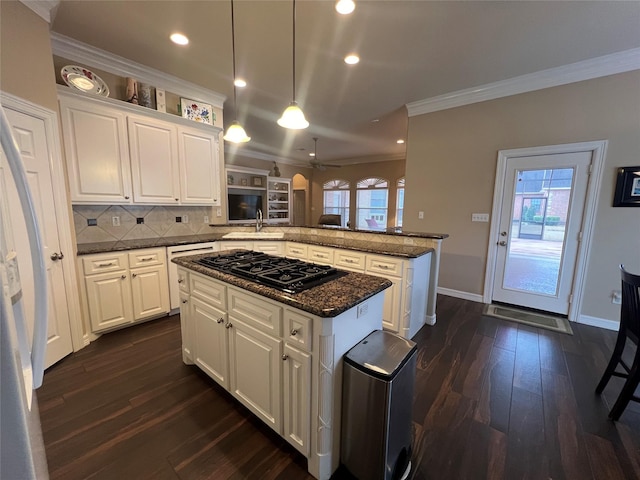 kitchen featuring hanging light fixtures, a center island, white cabinets, and kitchen peninsula