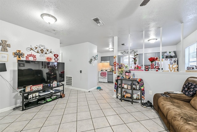 tiled living room featuring a textured ceiling