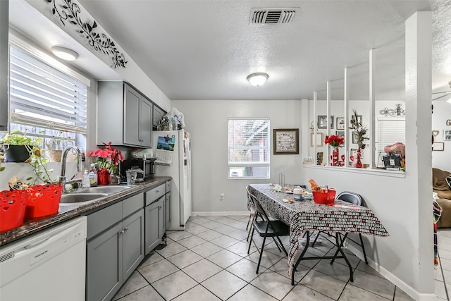 kitchen featuring gray cabinetry, sink, white appliances, and a textured ceiling