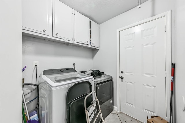 laundry area with washing machine and dryer and cabinets