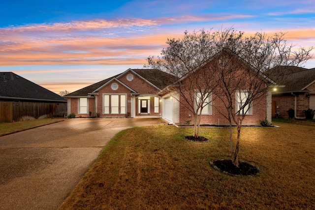 view of front of home with a garage and a lawn