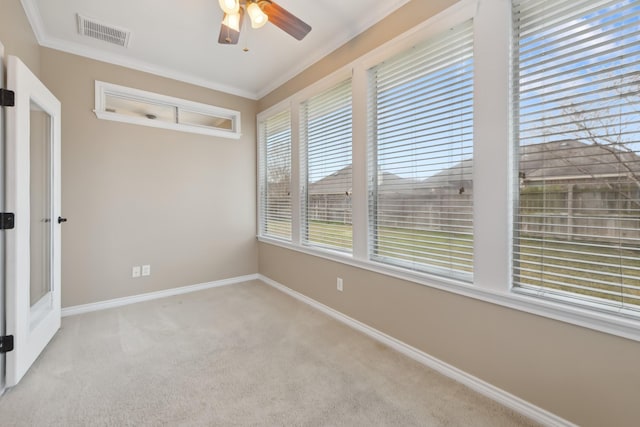 unfurnished room featuring crown molding, light colored carpet, and ceiling fan