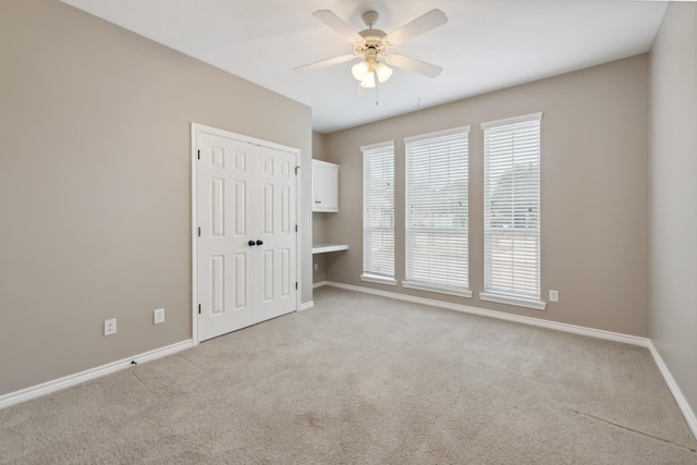 unfurnished room featuring ceiling fan and light carpet