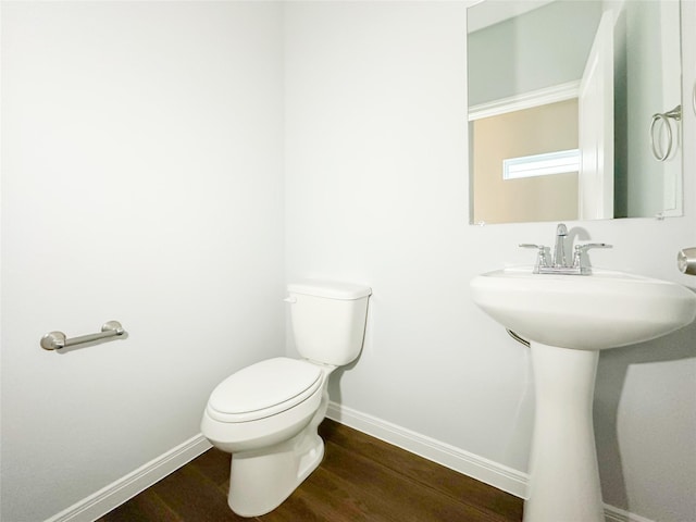 bathroom featuring sink, wood-type flooring, and toilet