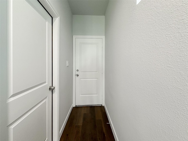 corridor with hardwood / wood-style flooring