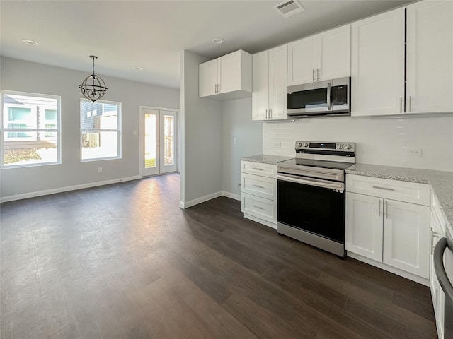 kitchen featuring white cabinetry, appliances with stainless steel finishes, decorative light fixtures, and light stone counters