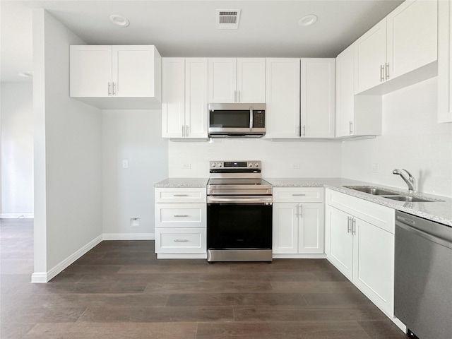 kitchen with light stone counters, sink, stainless steel appliances, and white cabinets