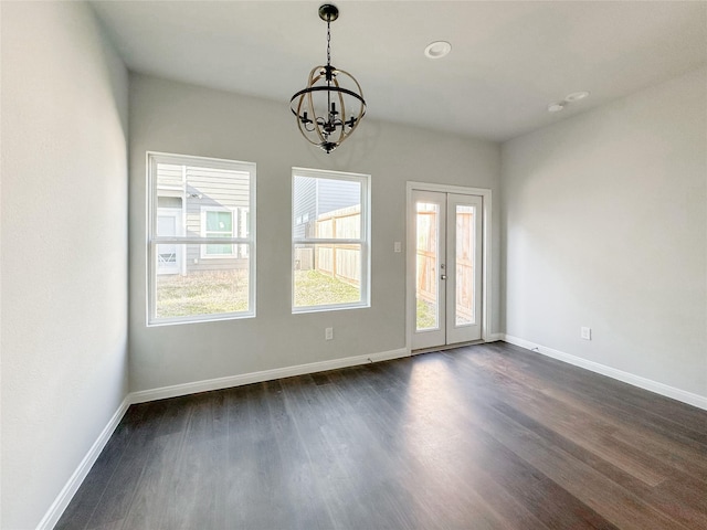 spare room featuring dark wood-type flooring, a wealth of natural light, and french doors