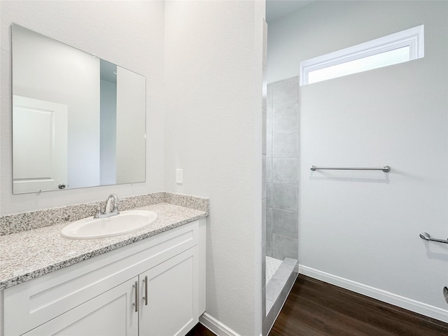 bathroom with vanity, hardwood / wood-style flooring, and a shower