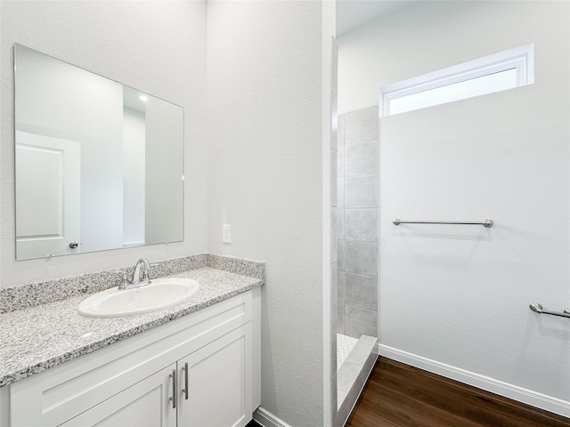 bathroom with wood-type flooring, vanity, and walk in shower