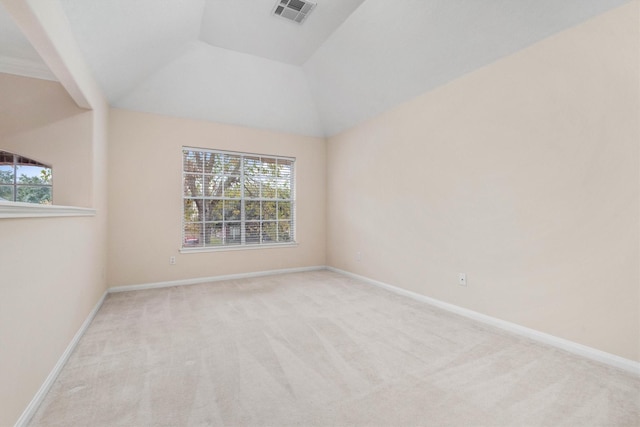 unfurnished room with vaulted ceiling, light carpet, and a wealth of natural light