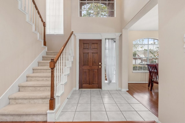 tiled foyer entrance featuring a towering ceiling