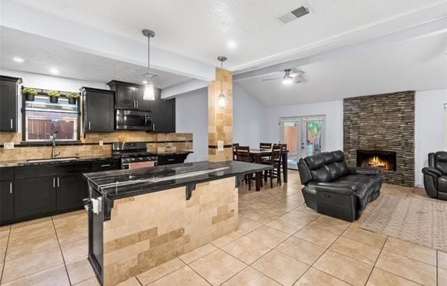 kitchen featuring sink, hanging light fixtures, a kitchen breakfast bar, stainless steel appliances, and backsplash