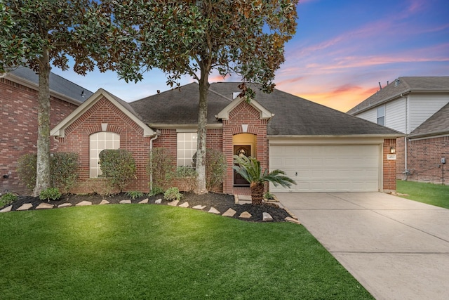 view of front of home with a yard and a garage