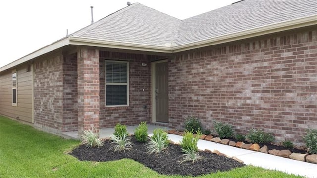 view of exterior entry with a lawn