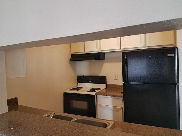 kitchen with white cabinetry, black fridge, electric range oven, and sink