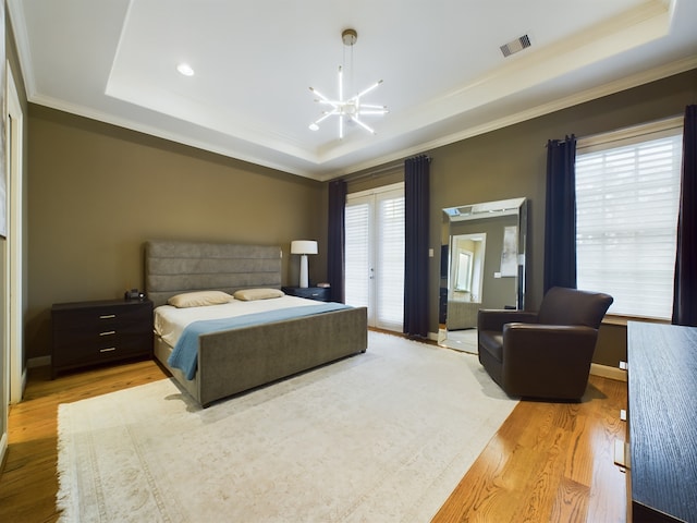 bedroom featuring crown molding, access to outside, light wood-type flooring, a raised ceiling, and a notable chandelier