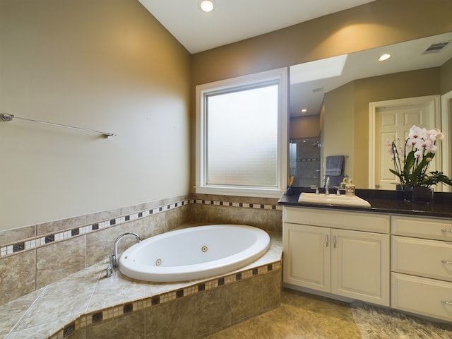 bathroom with tile patterned flooring, vanity, and plus walk in shower