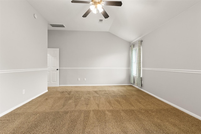 carpeted spare room featuring vaulted ceiling and ceiling fan