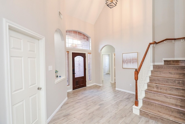 foyer featuring high vaulted ceiling and light wood-type flooring