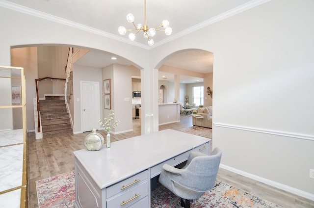 office space featuring crown molding, a notable chandelier, and light wood-type flooring