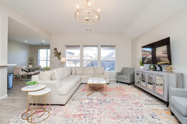 living room featuring a notable chandelier and light wood-type flooring