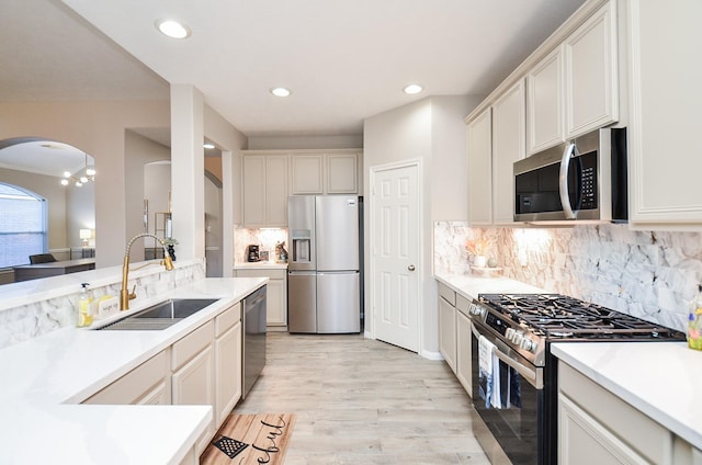 kitchen with white cabinetry, appliances with stainless steel finishes, sink, and light hardwood / wood-style floors