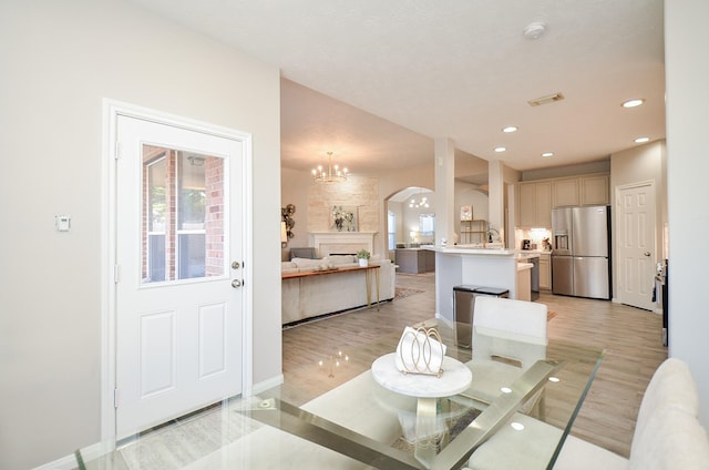 dining room with an inviting chandelier, sink, and light hardwood / wood-style flooring