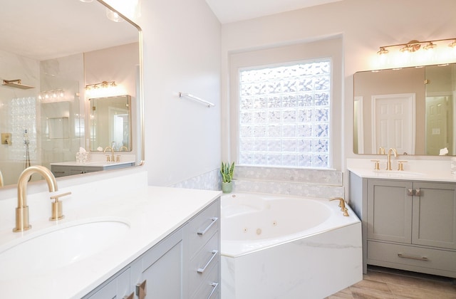 bathroom with vanity, hardwood / wood-style floors, a wealth of natural light, and separate shower and tub