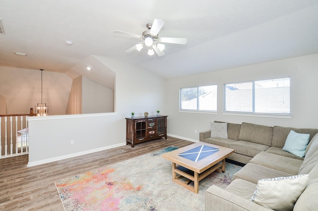 living room featuring hardwood / wood-style floors, vaulted ceiling, and ceiling fan