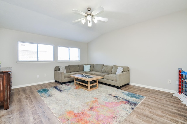 living room with hardwood / wood-style flooring, ceiling fan, and lofted ceiling