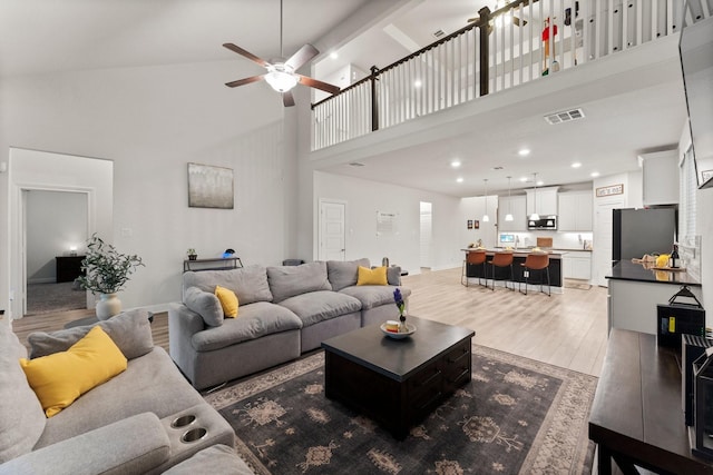 living room featuring hardwood / wood-style floors, a towering ceiling, and ceiling fan