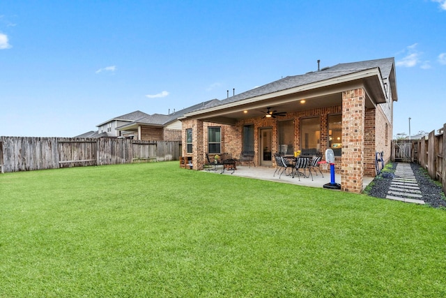 back of property with a lawn, a patio, and ceiling fan