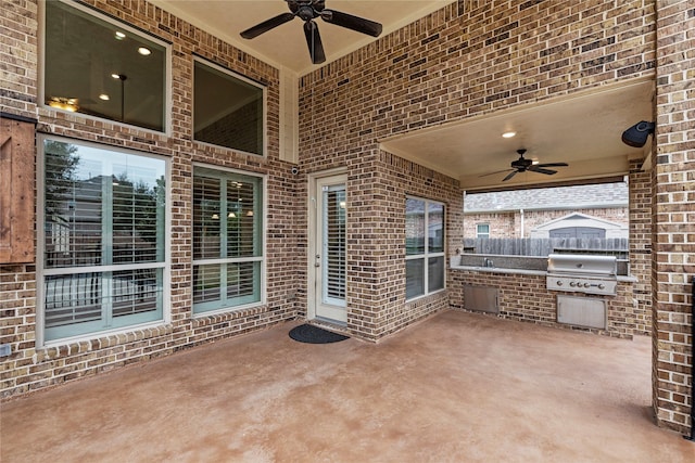 view of patio / terrace with a ceiling fan, fence, grilling area, and an outdoor kitchen