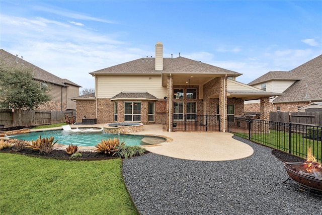 back of property with ceiling fan, a fenced backyard, a fire pit, brick siding, and a yard