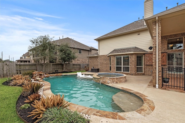 view of swimming pool with a pool with connected hot tub, a fenced backyard, and a patio