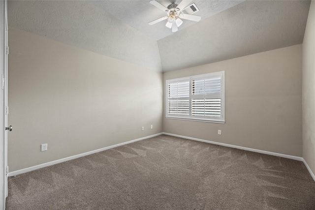 carpeted empty room featuring ceiling fan, a textured ceiling, visible vents, baseboards, and vaulted ceiling