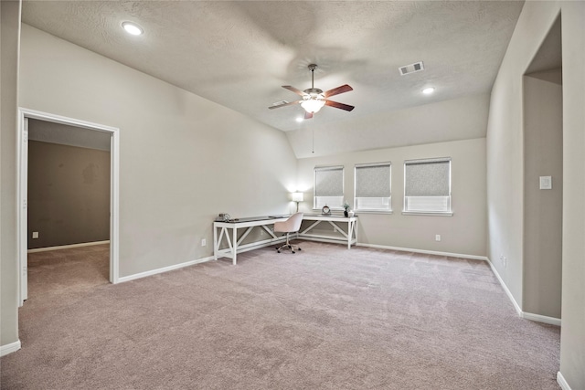 spare room featuring visible vents, baseboards, light colored carpet, lofted ceiling, and ceiling fan