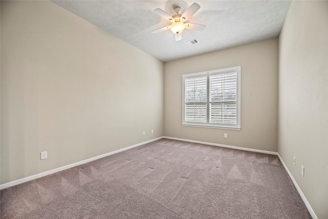 unfurnished room with light carpet, baseboards, visible vents, a ceiling fan, and a textured ceiling