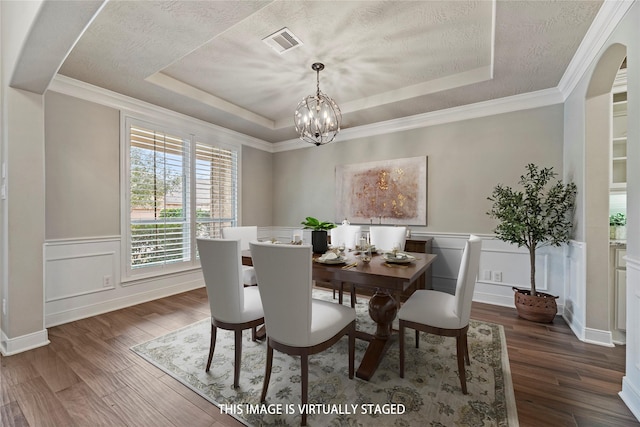 dining room featuring dark wood-style floors, a raised ceiling, visible vents, and an inviting chandelier