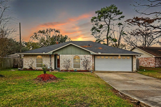 ranch-style house featuring a garage and a yard