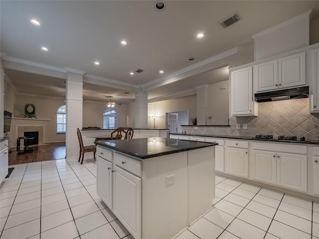 kitchen with under cabinet range hood, white cabinetry, and open floor plan