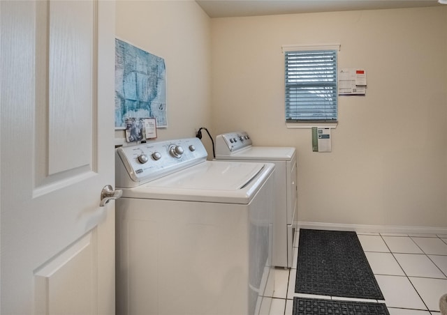 laundry room featuring light tile patterned floors, laundry area, baseboards, and washer and dryer