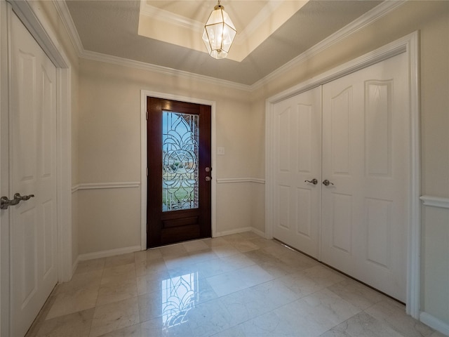 foyer entrance featuring a raised ceiling and crown molding