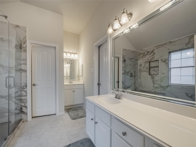 bathroom featuring vaulted ceiling, two vanities, a sink, and a marble finish shower