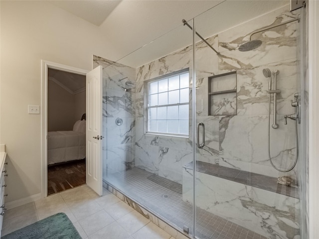 ensuite bathroom with ensuite bathroom, tile patterned flooring, a marble finish shower, and vanity