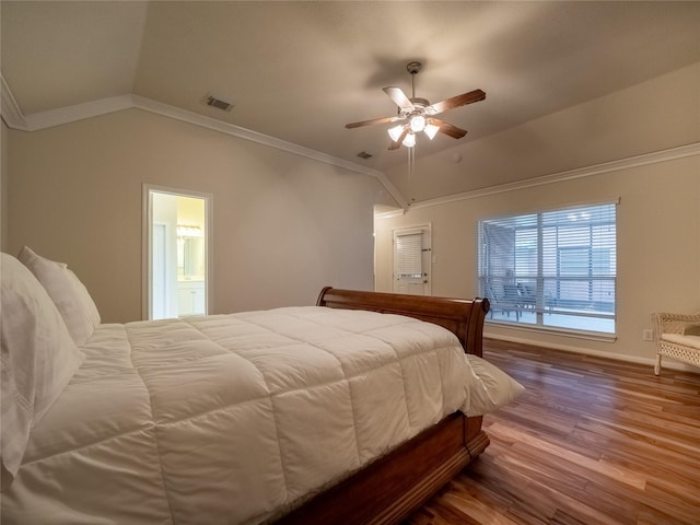 bedroom with visible vents, ornamental molding, vaulted ceiling, and wood finished floors